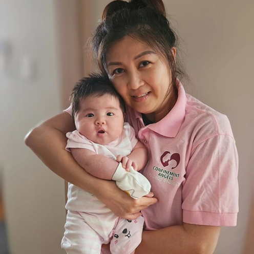 Confinement Angels nanny holding newborn
