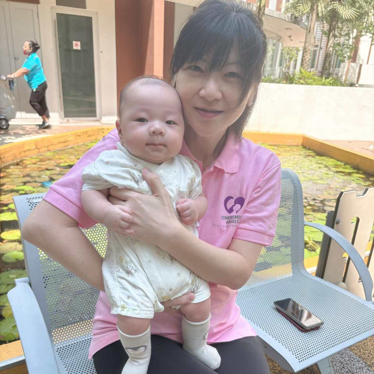 professional nanny Singapore from Confinement Angels lovingly carrying a newborn